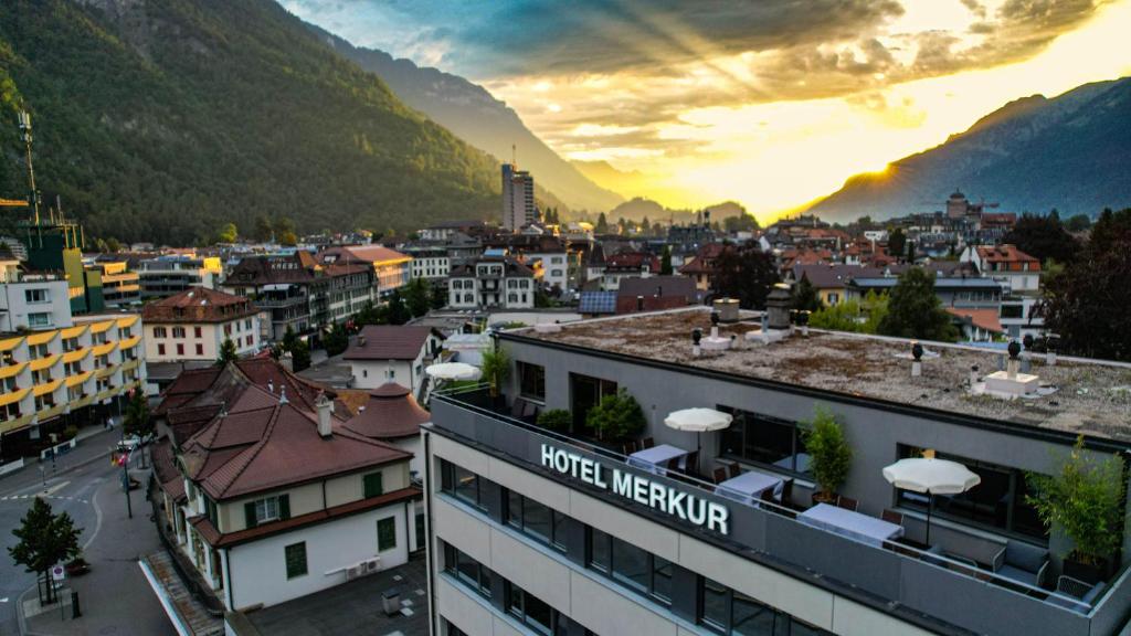 uma vista para uma cidade com montanhas ao fundo em Hotel Merkur - West Station em Interlaken