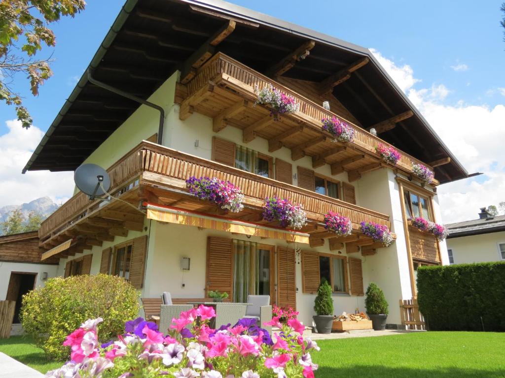 a house with flowers in the front yard at Haus Stegen in Maria Alm am Steinernen Meer