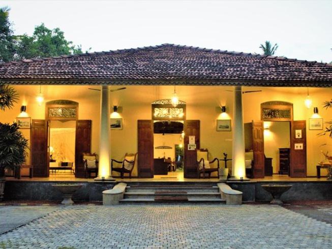 a house with a porch with benches in front of it at Villa 386 in Ahungalla