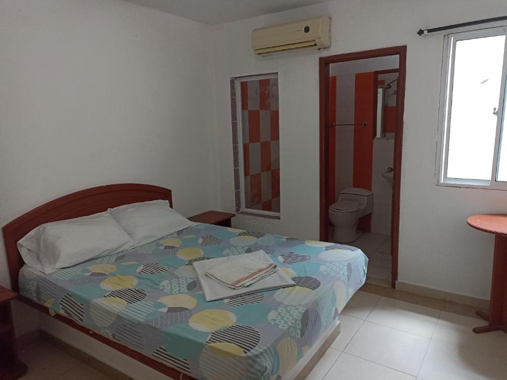 1 dormitorio con cama, aseo y ventana en HOTEL VIP COMFORT, en Santa Marta