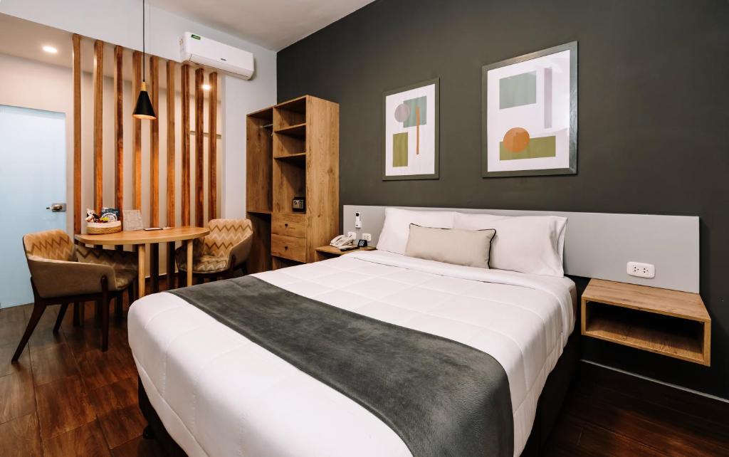 um quarto com uma grande cama branca e uma mesa em TARATA BOUTIQUE HOTEL em Lima