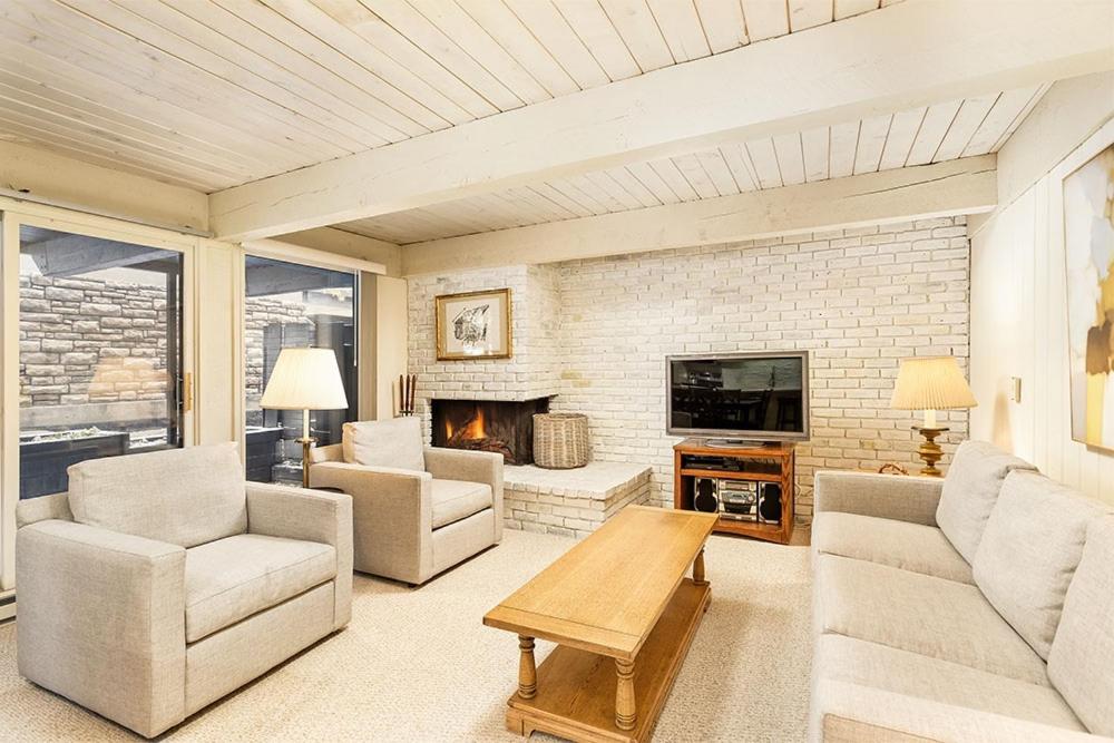 a living room with a couch and a fireplace at Chateau Roaring Fork Unit 37, Spacious Condo, Close to Downtown. Pool, Hot Tub, Fitness Center in Aspen