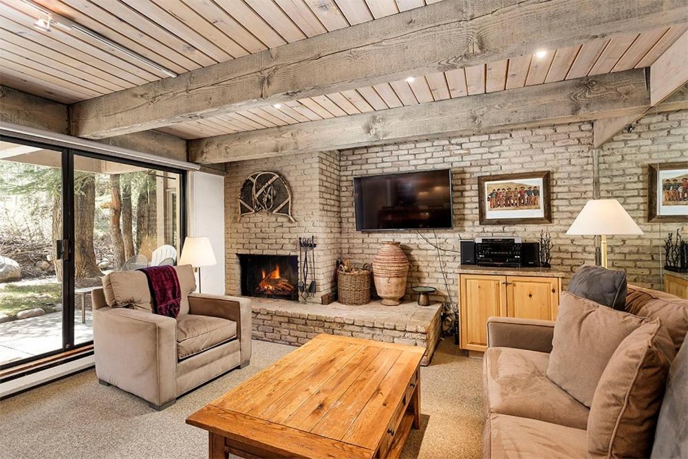 a living room with a couch and a fireplace at Chateau Eau Claire Unit 8, Riverfront Condo, Walking Distance to Town in Aspen