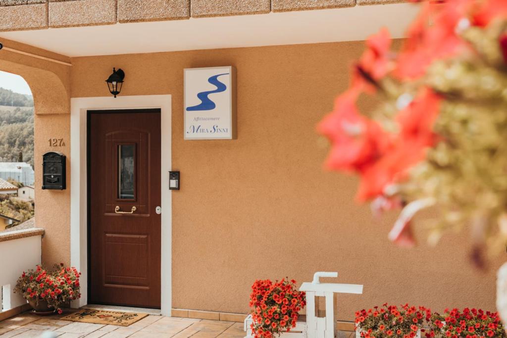un bâtiment avec une porte et des fleurs devant lui dans l'établissement Affittacamere Mira Sinni, à Episcopia