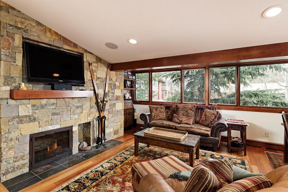 a living room with a couch and a fireplace at Fasching Haus Unit 5, Deluxe Condo with Great Natural Light & Amazing Location in Aspen
