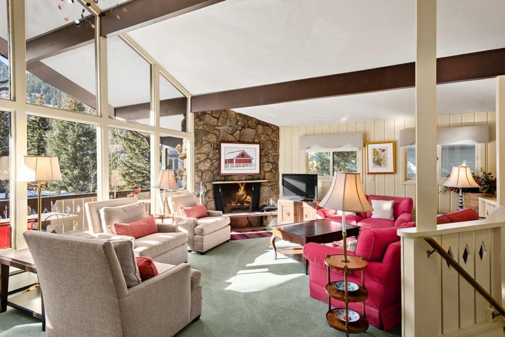 a living room with red furniture and a fireplace at 118 E Bleeker Home in Aspen
