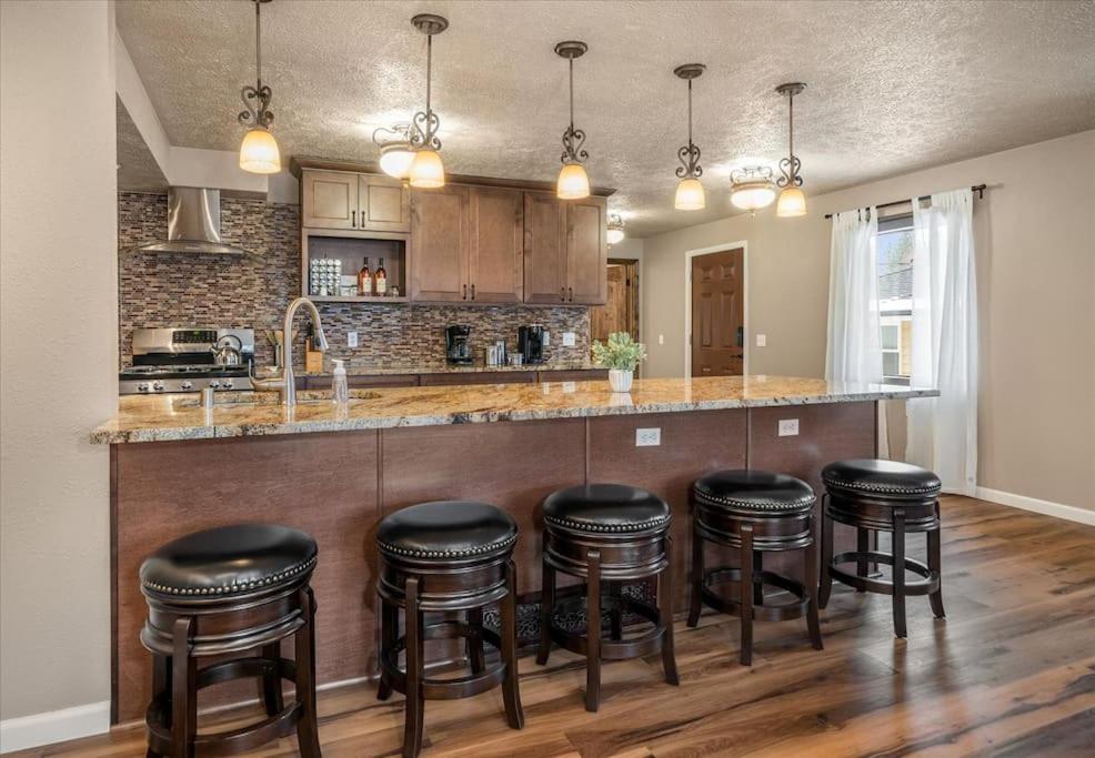 una cucina con bancone e sgabelli neri di Theatrical Escape South Hill Home near Downtown a Spokane