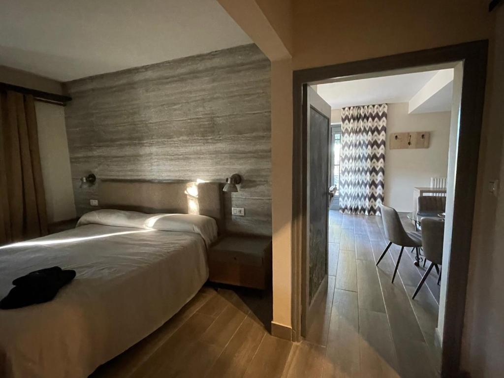 a bedroom with a bed and a table and a desk at Casa Rural Camino de Hierro I y II in La Fregeneda