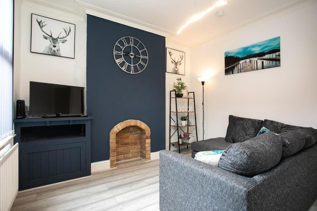 a living room with a gray couch and a fireplace at *Cosy home with parking for you* in Derby