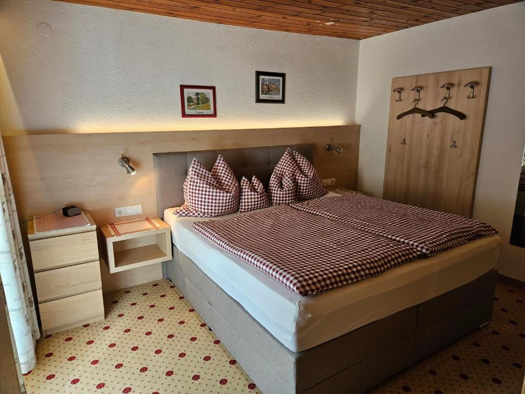 Schlafzimmer mit einem Bett mit roten und weißen Kissen in der Unterkunft Appartements Waldruh in Achenkirch