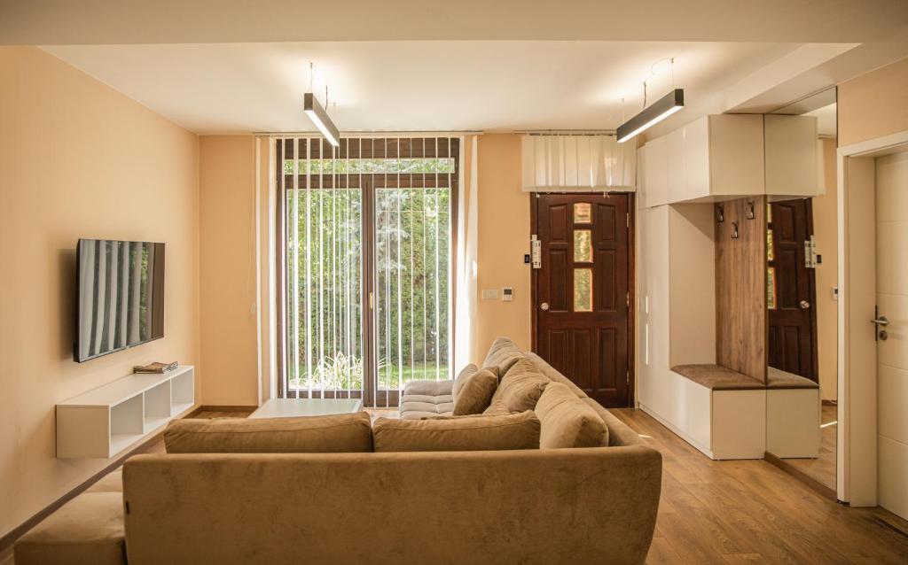 uma sala de estar com um sofá e uma grande janela em Green Oasis in the City Center em Pristina