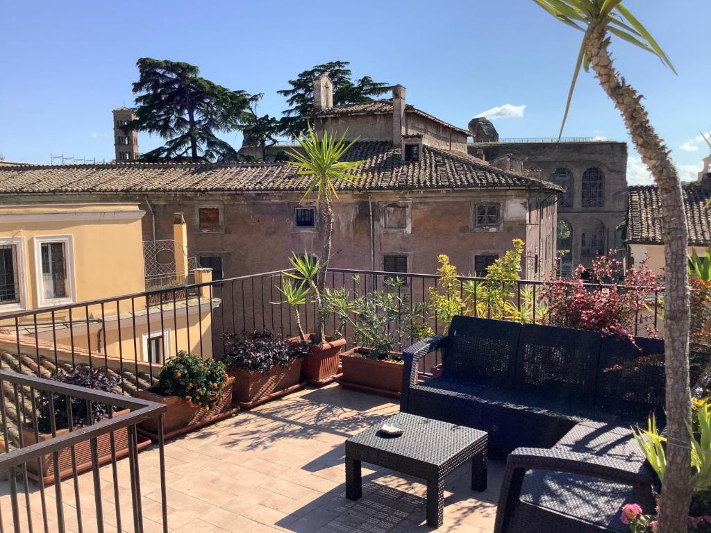 einen Balkon mit einer Bank und einem Tisch und einigen Pflanzen in der Unterkunft Frangipane 31 Monti Terrace in Rom