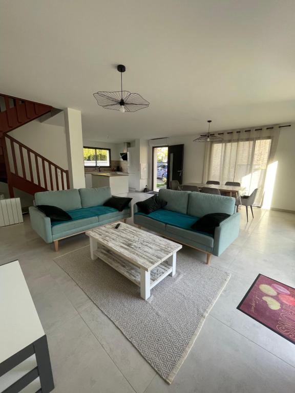 a living room with blue couches and a coffee table at Maison Bijou 3 chambres à 10min de DisneyLand Paris in Chalifert