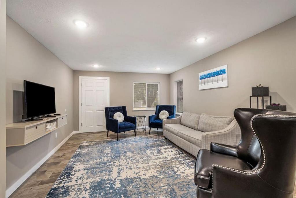un salon avec un canapé, des chaises et une télévision dans l'établissement Urban Chateau Downtown Retreat, à Grand Rapids