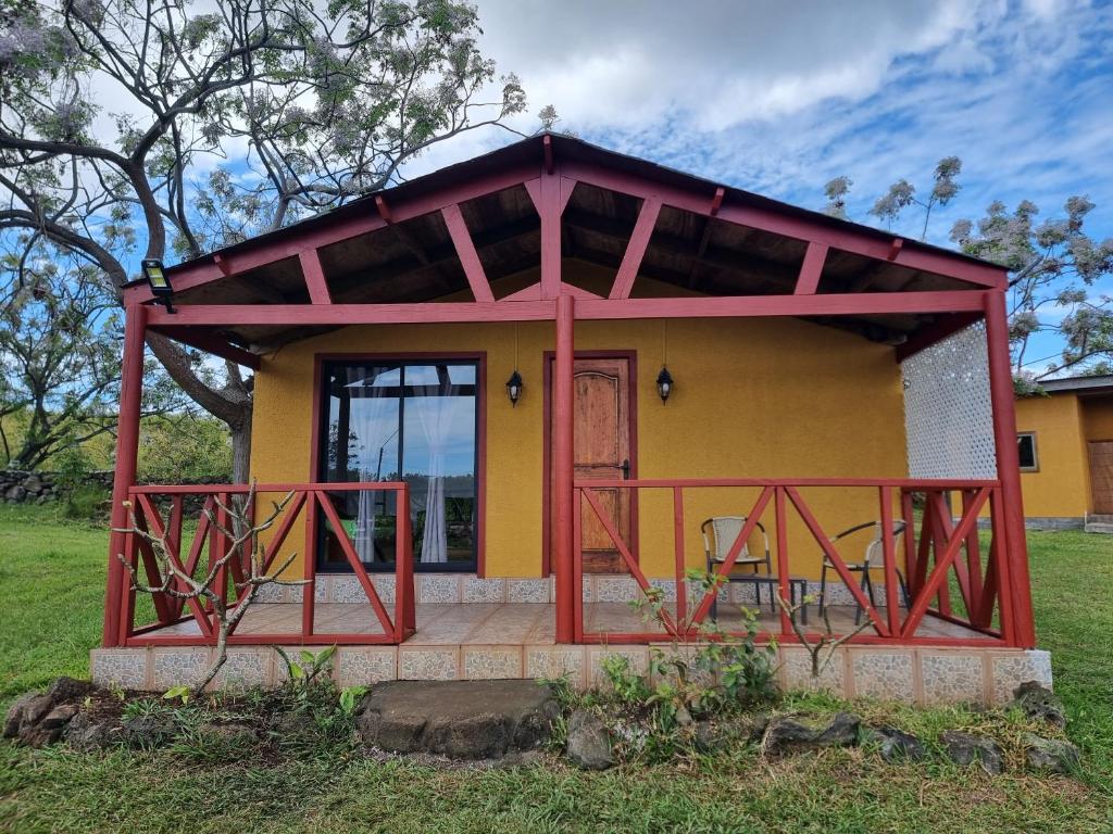 una pequeña casa con techo rojo y porche en Mika's House, en Hanga Roa