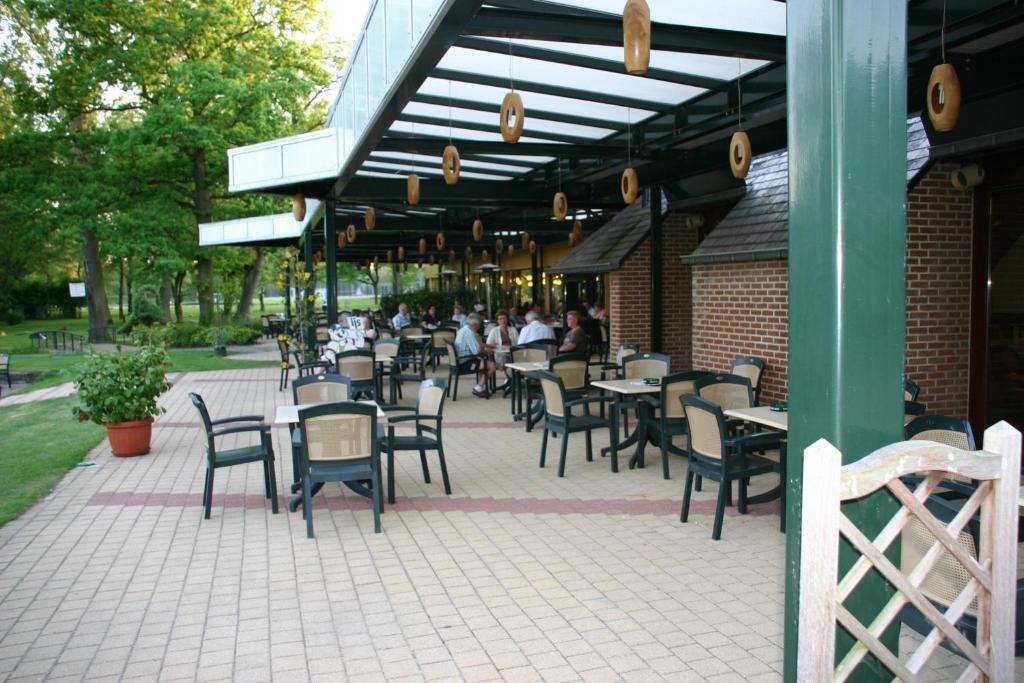 a patio of a restaurant with tables and chairs at Hotel De Watermolen in Bocholt