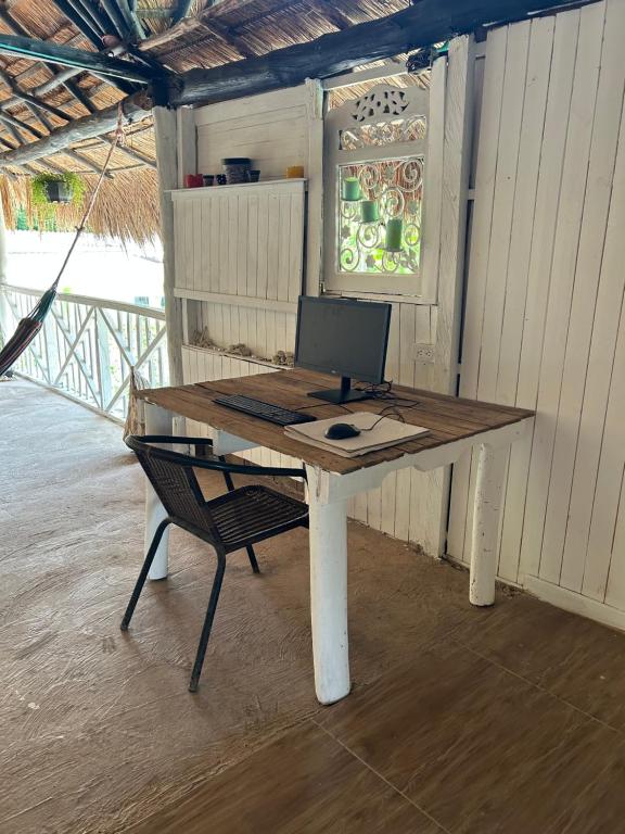 a desk with a computer on it with a chair at Oasis at Eco Hostal Villa Canada in Playa Punta Arena
