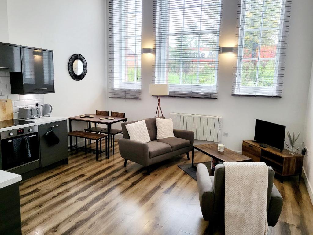a living room with a couch and a table at Burkhardt Hall- Parking Included- Sleeps 4 in Swindon
