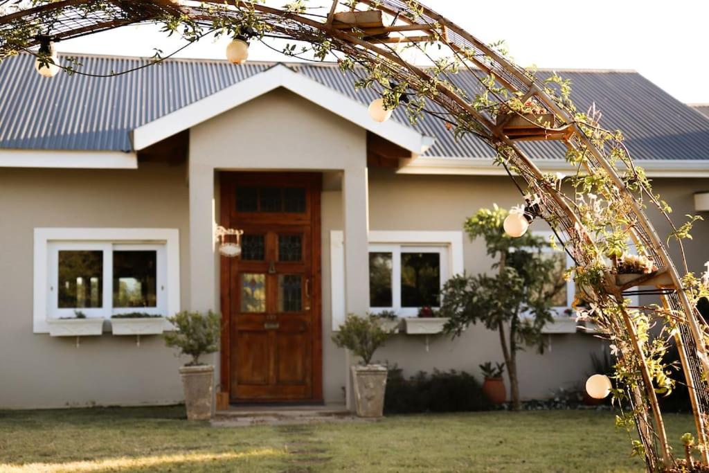 una casa con techo azul y puerta de madera en Tranquility Farmstays, en Winterton