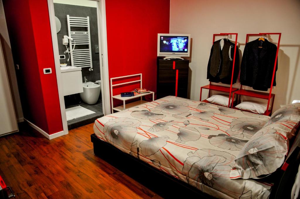 um quarto com uma cama e uma televisão em Eva & Diabolik's Room Milano Centro Duomo em Milão