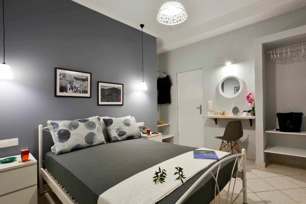 a bedroom with a bed with a gray wall at Casa Mia Apartment in Corfu
