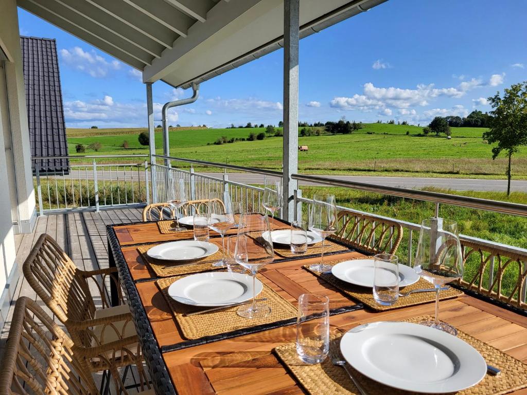 a table on a balcony with a view of a field at SiOUX: Penthouse „BOHO“ mit traumhaftem Ausblick in Leutkirch im Allgäu