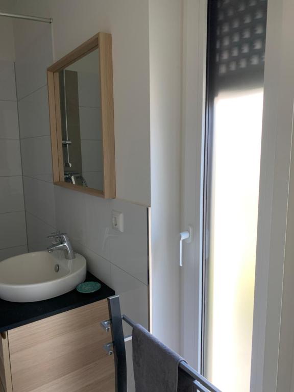a bathroom with a sink and a mirror at Messe Apartment in Hannover