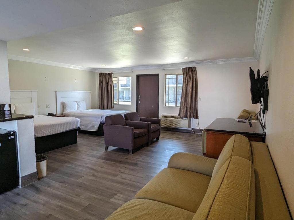 ein Hotelzimmer mit 2 Betten und einem Sofa in der Unterkunft Valley Inn in Mission Hills