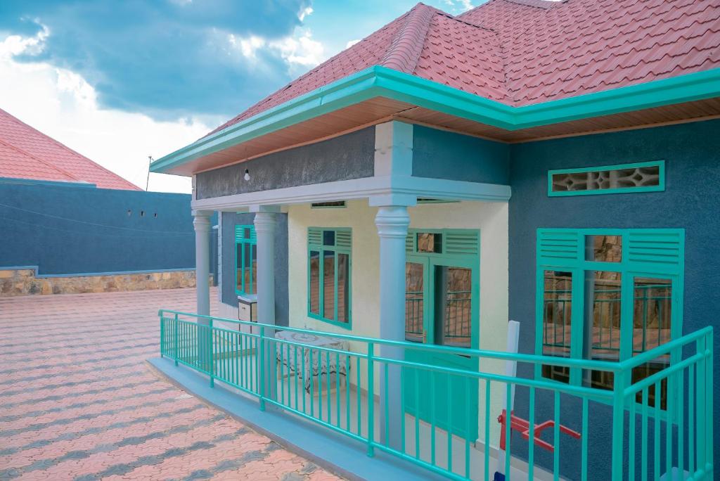 une petite maison bleue avec un toit rouge dans l'établissement Family Oasis, à Kigali
