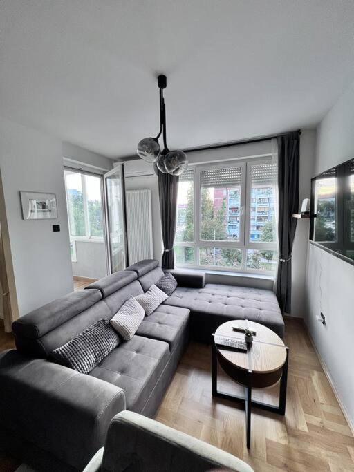 uma sala de estar com um sofá e uma mesa em Greywood relax apartment em Zagreb