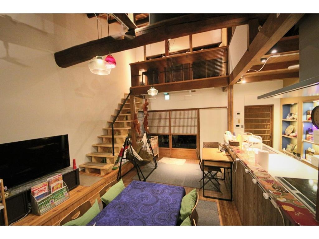 a living room with a staircase and a table at Nishijin no Sato - Vacation STAY 54993v in Kyoto