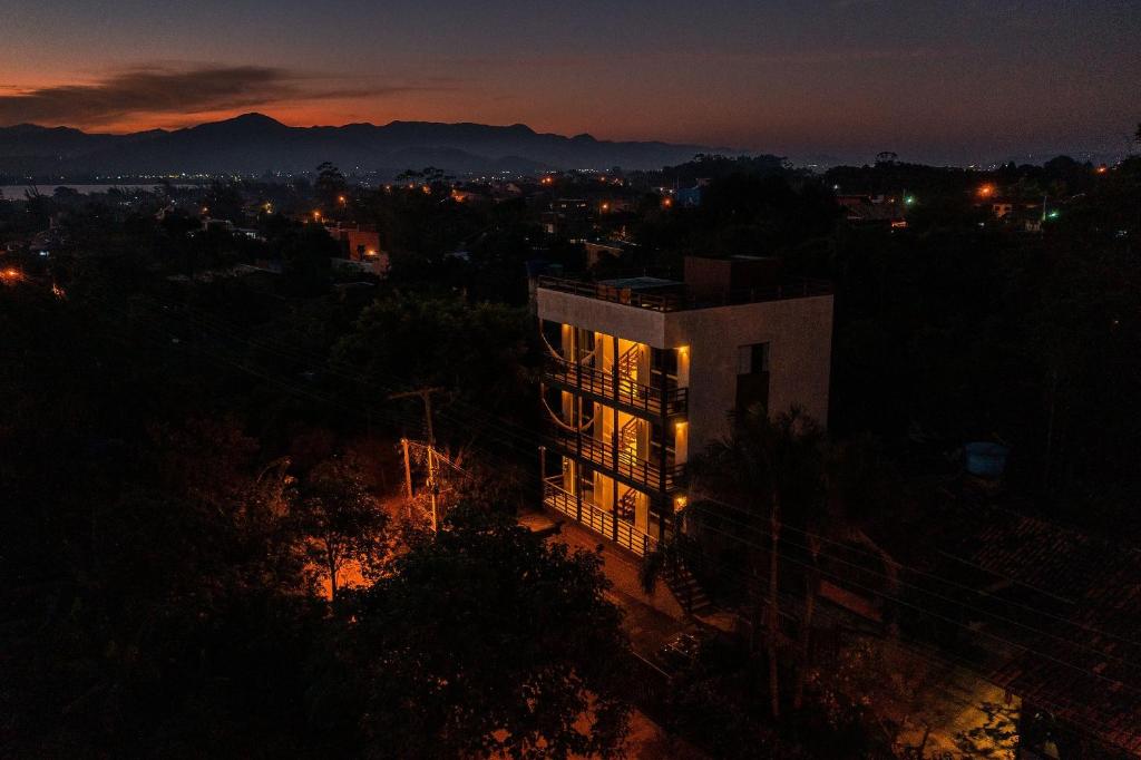 un edificio de noche con las luces encendidas en Lugar ao Sol - Flats - Praia do Rosa - SC en Praia do Rosa