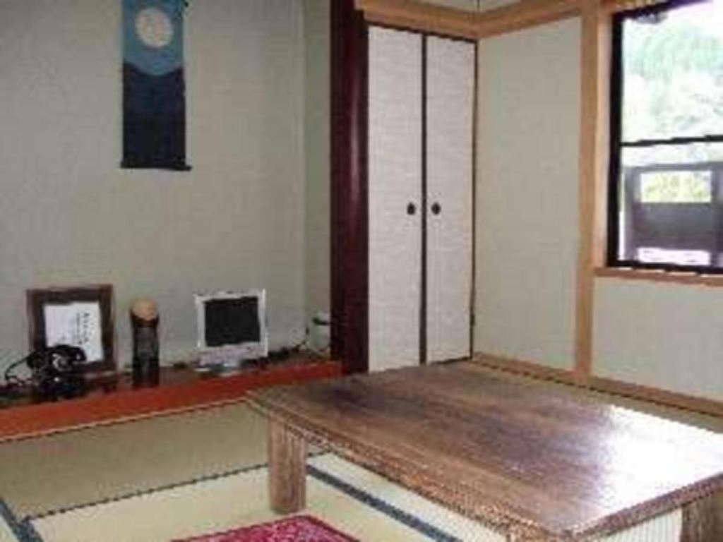 a living room with a wooden table and a window at Ryokan Yamashiroya - Vacation STAY 21536v in Yufu