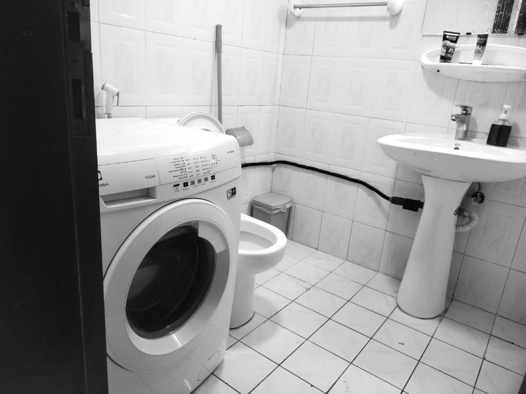 een badkamer met een wasmachine en een wastafel bij 05 Burjuman metro stations Unisex Hostel Private room - 05 in Dubai