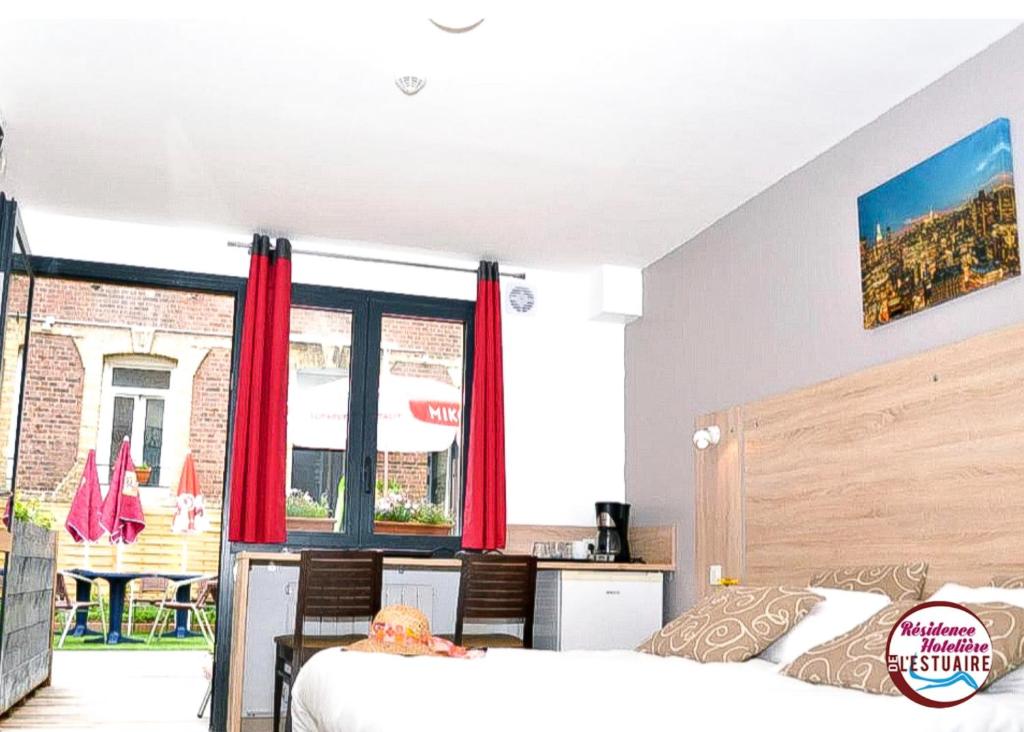 - une chambre avec un lit et une grande fenêtre dans l'établissement Résidence Hôtelière de l'Estuaire, au Havre