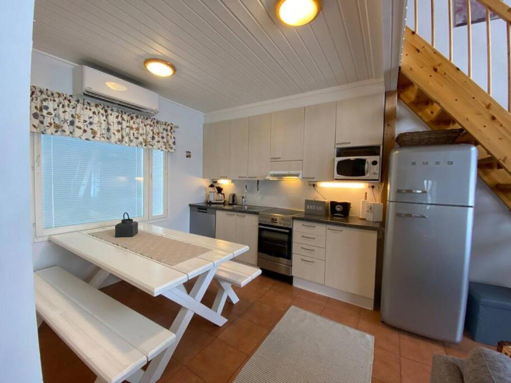 une cuisine avec une table et un réfrigérateur dans l'établissement Himoshuvi 2, à Säyrylä