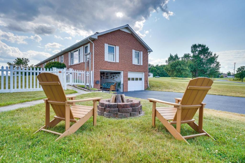 two chairs sitting in the grass in front of a house at The MD and PA Line Retreat Scenic Country Getaway! in Emmitsburg