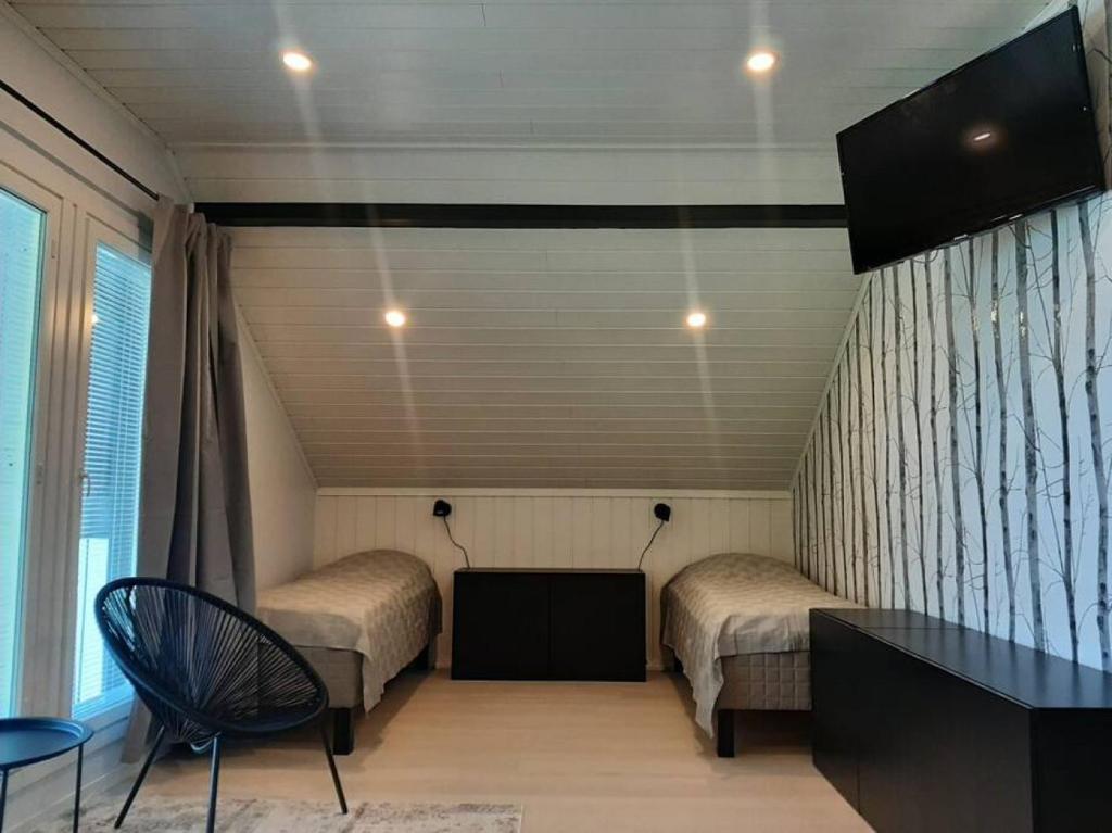 Zimmer mit 2 Betten, einem Tisch und einem Fenster in der Unterkunft Villa Pussilanranta Himos in Jämsä