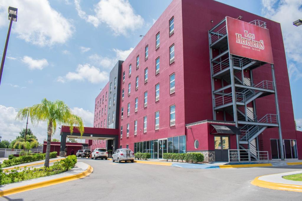 un bâtiment rouge avec un panneau sur son côté dans l'établissement Los Herederos Hotel Piedras Negras, 