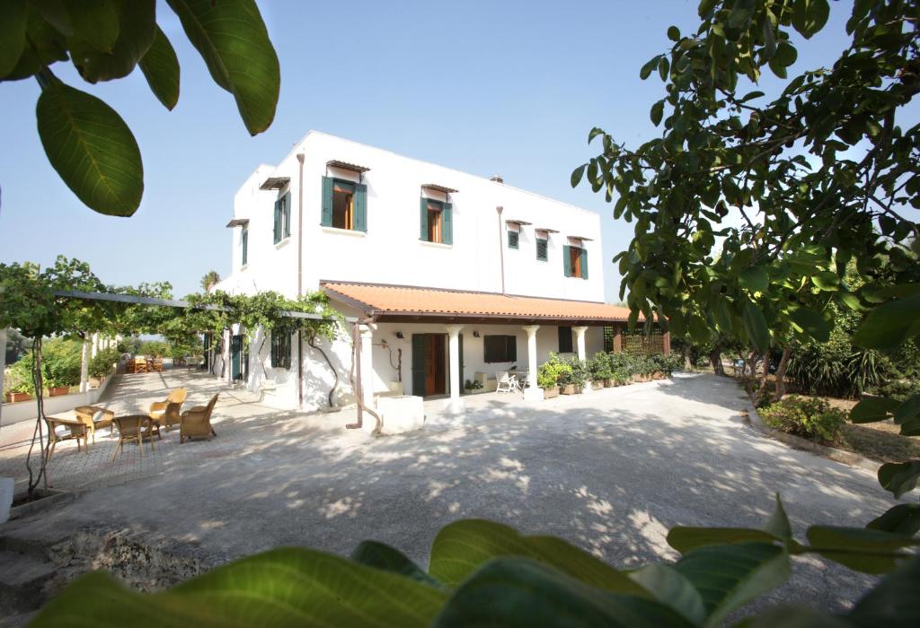 a white house with chairs and tables in front of it at B&B Casale Spisari in Galatone