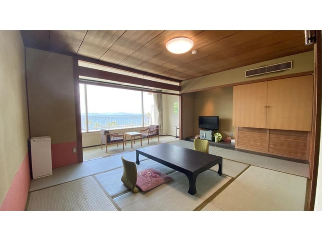 sala de estar con mesa y comedor en Nishiura Grand Hotel Kikkei - Vacation STAY 85448v en Gamagori