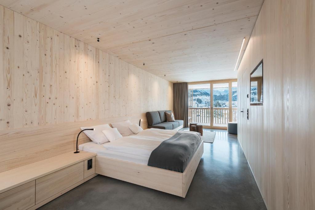 1 dormitorio con 1 cama grande y 1 silla en Bio-Hotel Oswalda-Hus, en Riezlern
