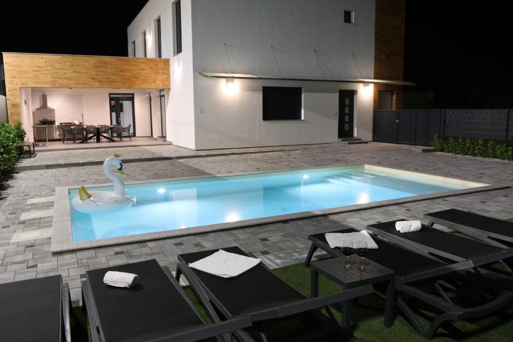 a swimming pool with a swan in the middle at Avangard HOME II in Rokovci