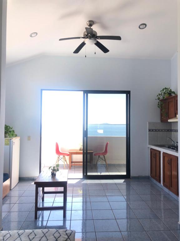 een woonkamer met een plafondventilator en een tafel bij Casa oceane in La Ventana
