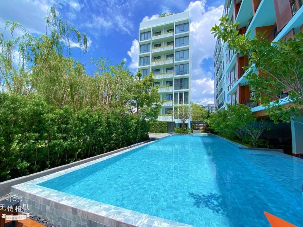 a swimming pool in front of a building at Tierra Residences in Bangkok
