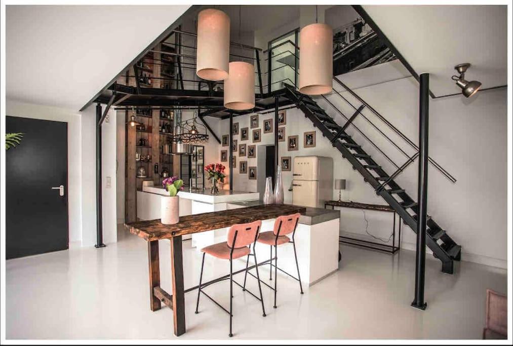 a kitchen with a table and chairs and a staircase at Ivory (car) loft / Carloft in Neuwied