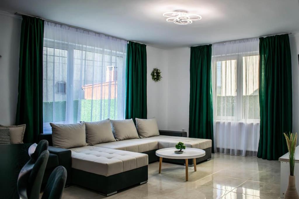 a living room with a couch and green curtains at Casa LUCAS in Bistriţa