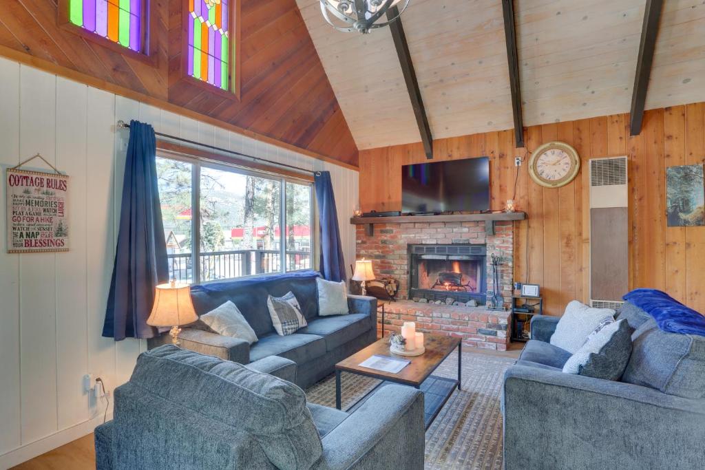 een woonkamer met 2 banken en een open haard bij Sherwood Cabin with Deck, Fire Pit and Lake Access! in Big Bear City