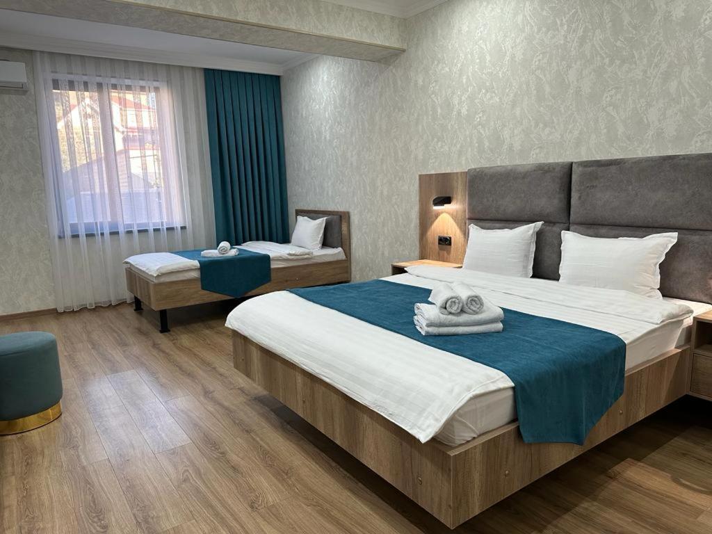 a bedroom with a large bed with towels on it at KORKEM Palace Hotel and Spa in Shymkent