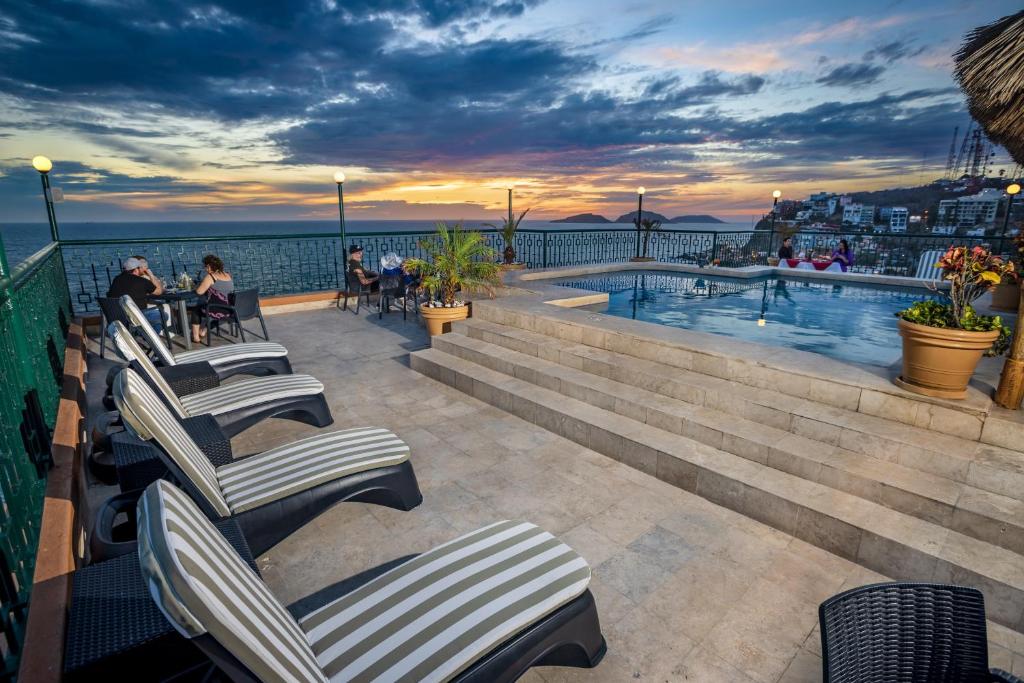 - une rangée de chaises longues sur une terrasse avec piscine dans l'établissement Best Western Posada Freeman, à Mazatlán